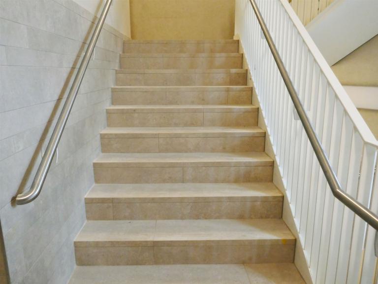 Die marmorierten Feinsteinzeugfliesen wurden auch auf den Treppenstufen und an Teilen der Wandflächen verlegt (Foto: Sopro)