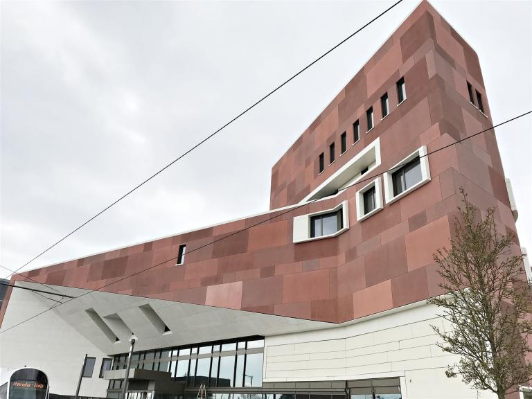 Die Luxemburger Nationalbibliothek mit ihrer in changierenden Sandstein-Rottönen gehaltenen Fassade zeigt sich repräsentativ.